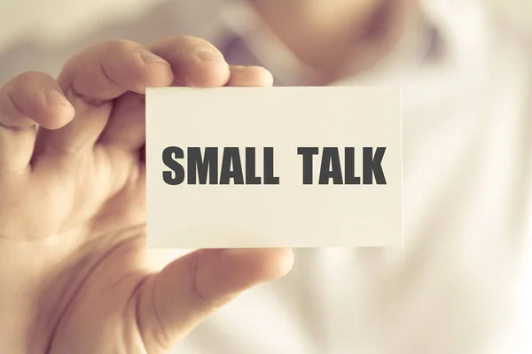 Бизнесмен, держащий SMALL TALK-карту — стоковое фото