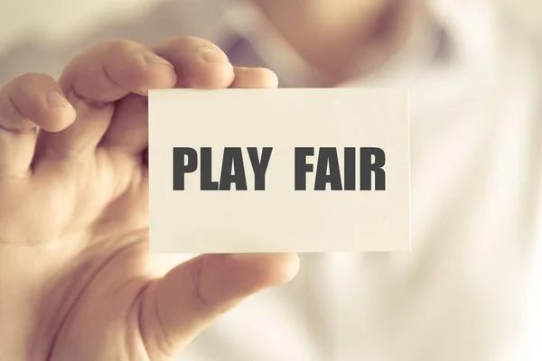 Бизнесмен с картой сообщения PLAY FAIR — стоковое фото