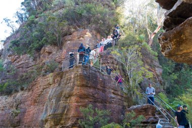 Tourists visiting Three Sisters rock formation in Katoomba, Australia. clipart
