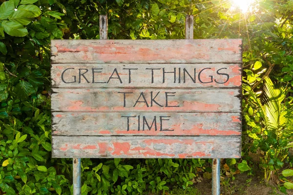 Great Things Take Time motivational quote written on old vintage board sign in the forrest, with sun rays in background. — Stock Photo, Image