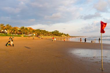 People on Kuta beach, Seminyak, one of popular attractions in Bali, Indonesia clipart