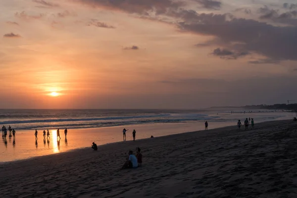 Personas en la playa de Kuta, Seminyak al atardecer en Bali, Indonesia —  Fotos de Stock