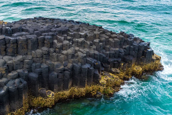 Crescent shaped hexagonal rock formations at Fingal Head, Australia — Stock Photo, Image