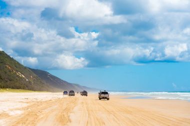 4wd vehicles at Rainbow Beach with coloured sand dunes, QLD, Australia clipart