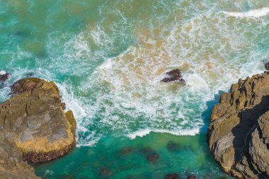 Havadan görünümü yeşil turkuaz su dalgaları Byron Bay, Avustralya üzerinden. Okyanus suları ve güneşli gün kayalarda doğa arka plan.