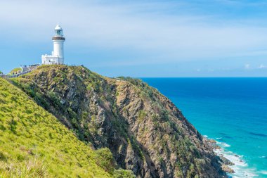 Cape Byron deniz feneri, yeşil turkuaz su dalgaları Byron Bay, Avustralya ile Avustralya anakarada en Doğu noktası üzerinde okyanus manzaralı. Arka planda tanımlanamayan turist.