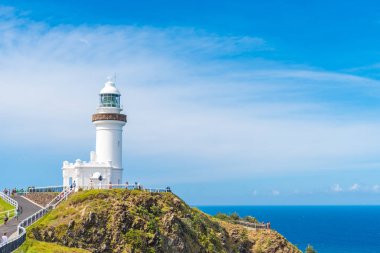Cape Byron deniz feneri, yeşil turkuaz su dalgaları Byron Bay, Avustralya ile Avustralya anakarada en Doğu noktası üzerinde okyanus manzaralı. Arka planda tanımlanamayan turist.