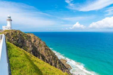 Cape Byron deniz feneri, yeşil turkuaz su dalgaları Byron Bay, Avustralya ile Avustralya anakarada en Doğu noktası üzerinde okyanus manzaralı. Arka planda tanımlanamayan turist.