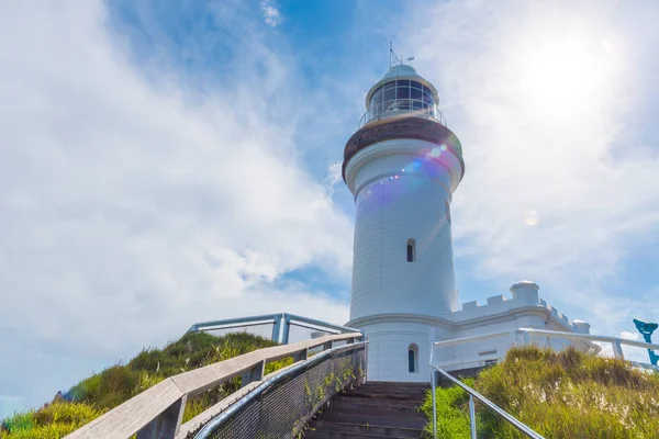 Vue sur le phare de Cape Byron, le point le plus à l'est du continent australien avec des vagues d'eau turquoise vertes à Byron Bay, en Australie. Effet fusée éclairante intentionnelle . — Photo