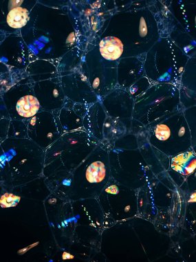 Karanlık arka planda sabun köpükleri. Gürültülü film tahılı, arka plan dokusu