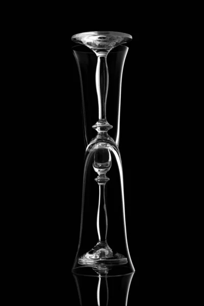 Svart och vit bild tomma glas glas på en svart bakgrund med en reflektion — Stockfoto