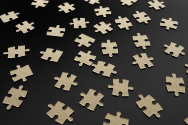 Bulmacalar siyah bir yüzeye saçılmış. Soyut arkaplan