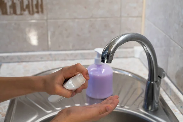hand hygiene a teenager washes his hands and uses an antiseptic to protect against the virus