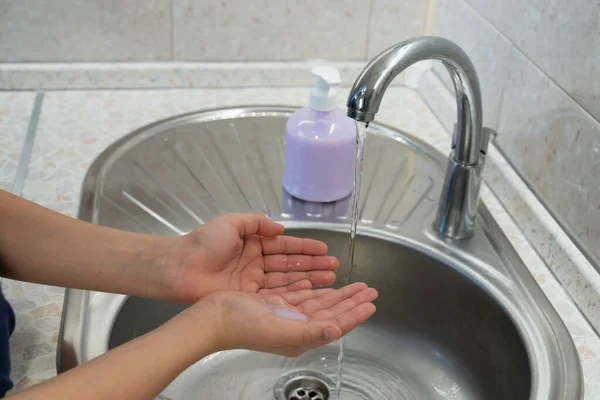 hand hygiene teen washes his hands with soap