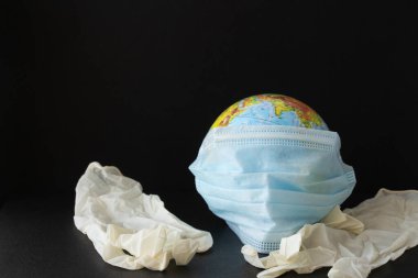 Corona virüsü konsepti. Dünya, Corona virüsüyle savaşmak için maske taktı. Virüse karşı savaş kavramı. Coronavirüs salgını ve koronavirüs gribi geçmişi.