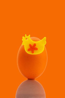 Turuncu arka planda Paskalya için turuncu tavuk yumurtası süslemesi.