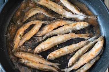 Yukarıdan yakından bakınca siyah bir tavada un gibi eritilmiş. deniz ürünleri