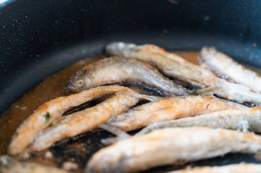 Yukarıdan yakından bakınca siyah bir tavada un gibi eritilmiş. deniz ürünleri