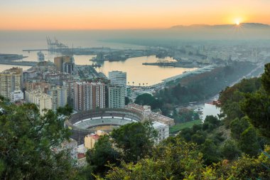 İspanyol Costa del Sol 'da gün batımında panoramik manzara şehrin panoramik manzarası, liman, evler, ağaçlar, yanan sokak lambaları ve mavi gökyüzü.