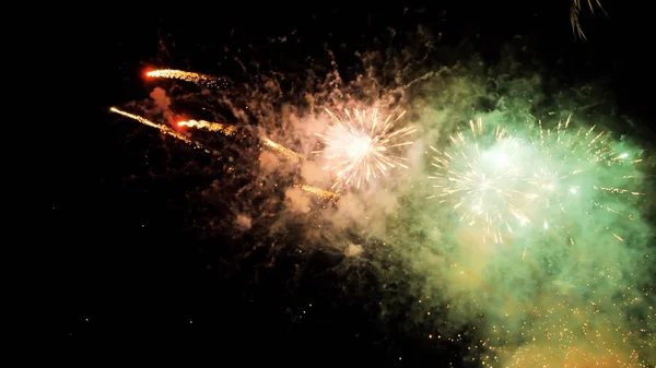 White and yellow green fireworks display on dark sky background. Brightly colorful fireworks on twilight background