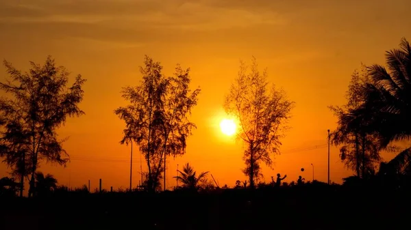 夕日の空を背景に人々を歩くシルエット — ストック写真