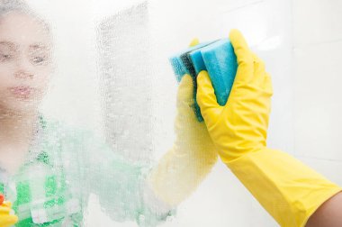 Kız banyoda ayna yıkıyor.