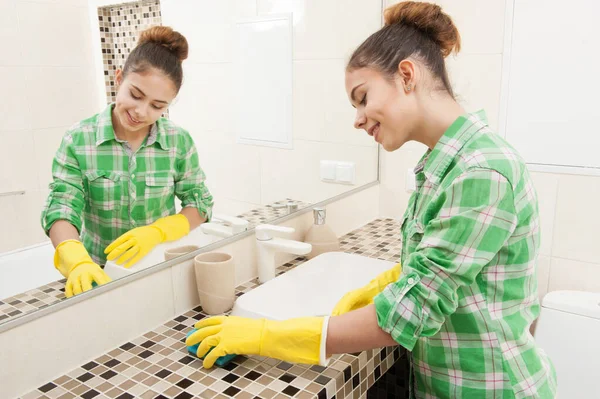 Girl washes a mirror in the bathroom — Stock Photo, Image