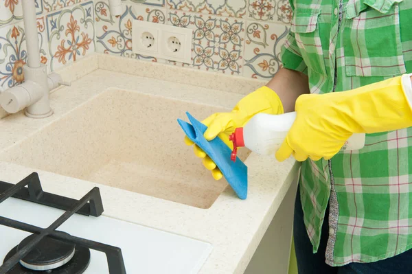 Girl Gloved washes cupboards, stove and sink in the kitchen — Stock Photo, Image