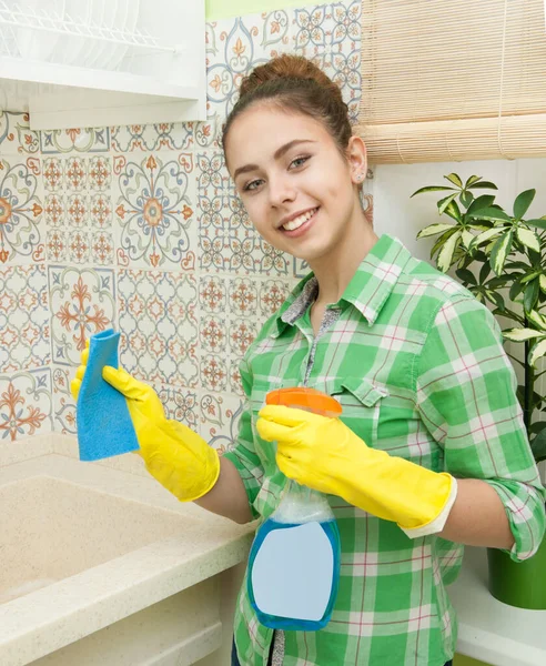 Mädchen mit Handschuhen wäscht Schränke, Herd und Spüle in der Küche — Stockfoto