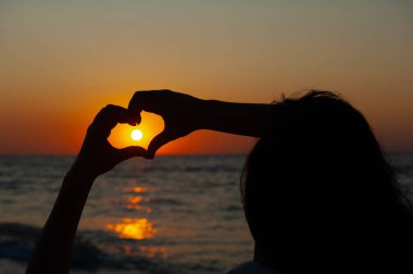 Kalp gün batımına karşı işaret, denizde gün doğumu
