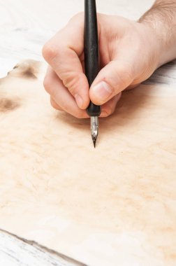 Kağıda kalem yazan bir erkek el.