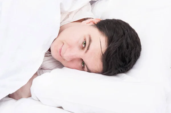 Brunetka mężczyzna śpi w łóżku — Zdjęcie stockowe