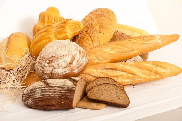 Pan, panes en surtido en una tabla de madera —  Fotos de Stock