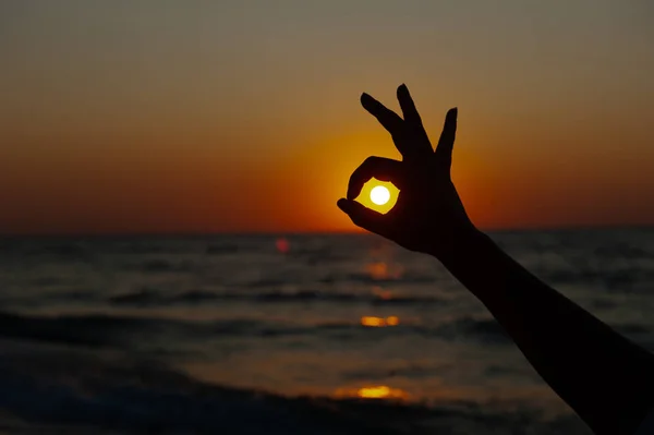 OK Знак против заката, восход солнца на море — стоковое фото