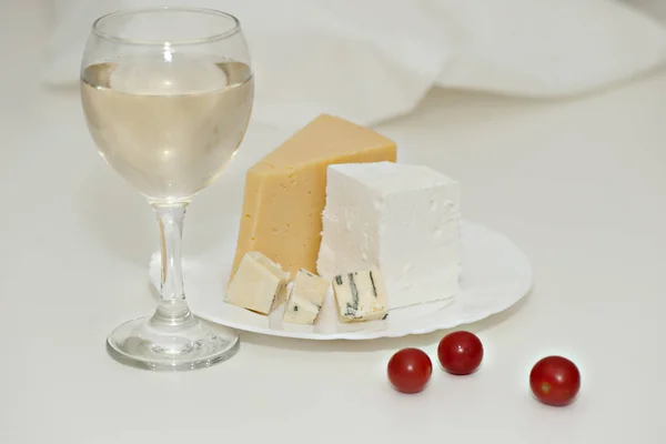 Glass of white wine and cheese on a plate — Stock Photo, Image