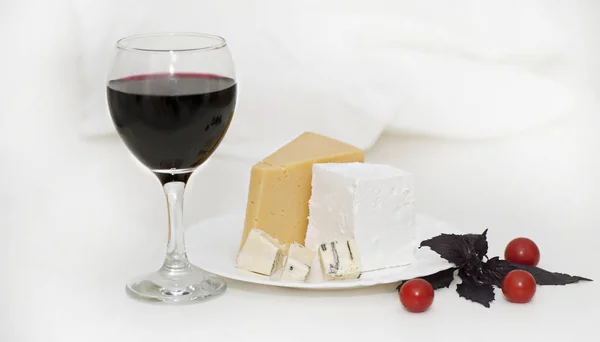 Copa de vino tinto y queso en un plato — Foto de Stock