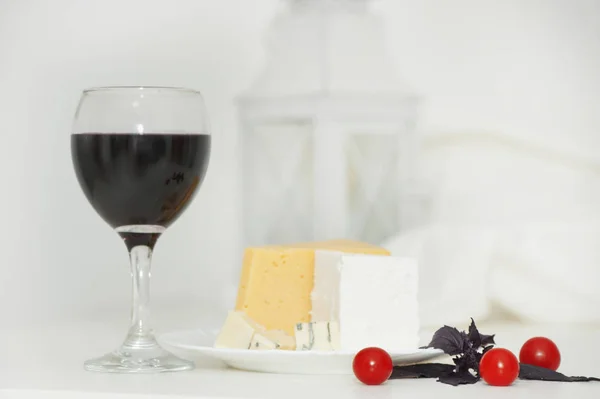 Copa de vino tinto y queso en un plato — Foto de Stock