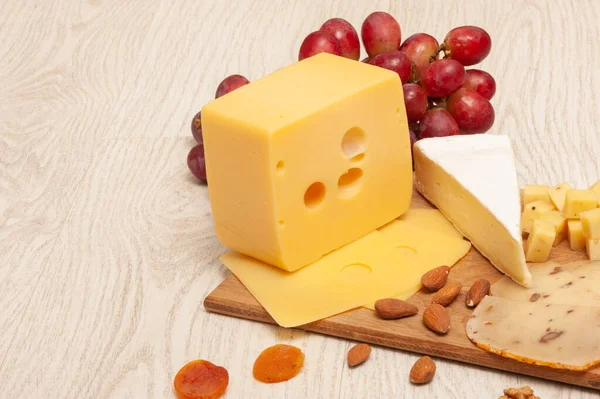 Diferentes tipos de queso en una tabla de madera. Vista superior —  Fotos de Stock