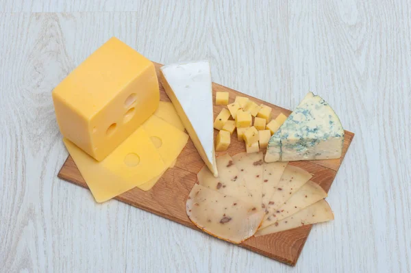 Diferentes tipos de queso Roquefort queso, queso de nuez, brie, en una tabla de madera . —  Fotos de Stock