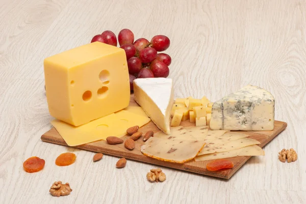 Diferentes tipos de queso en una tabla de madera. Vista superior —  Fotos de Stock