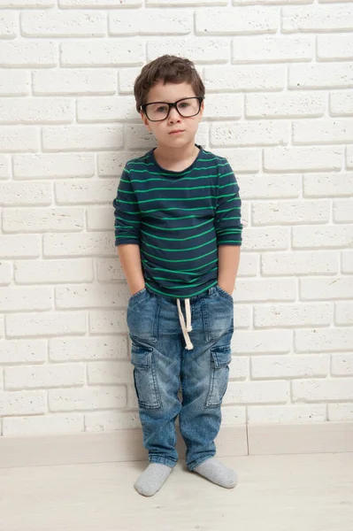 Niño pequeño en gafas contra una pared de ladrillo — Foto de Stock