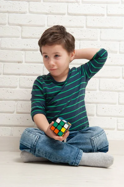 Kiev, Ucrania, 22 de marzo de 2020. boy plays with rubiks cube. Rubiks Cube inventado por un arquitecto húngaro Erno Rubik en 1974 . — Foto de Stock