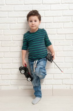 Oyuncak arabalı çocuk duvara yaslanmış.