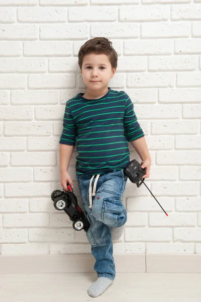Chłopiec z zabawką samochód na ścianie z cegły — Zdjęcie stockowe