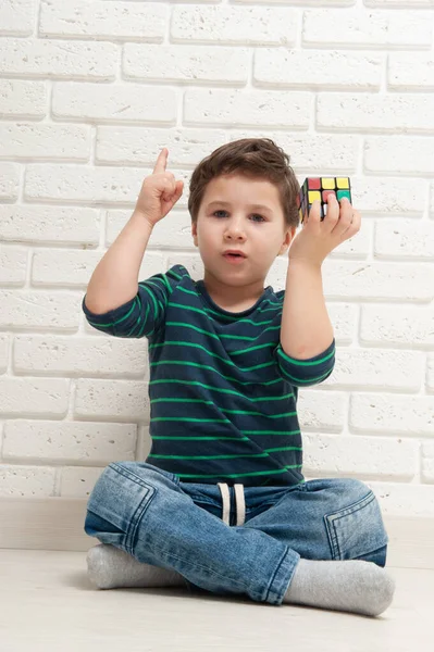 Kiev, Ucrania, 22 de marzo de 2020. boy plays with rubiks cube. Rubiks Cube inventado por un arquitecto húngaro Erno Rubik en 1974 . — Foto de Stock