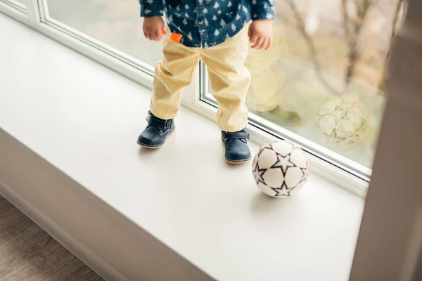 Benen ett litet barn som spelar boll — Stockfoto