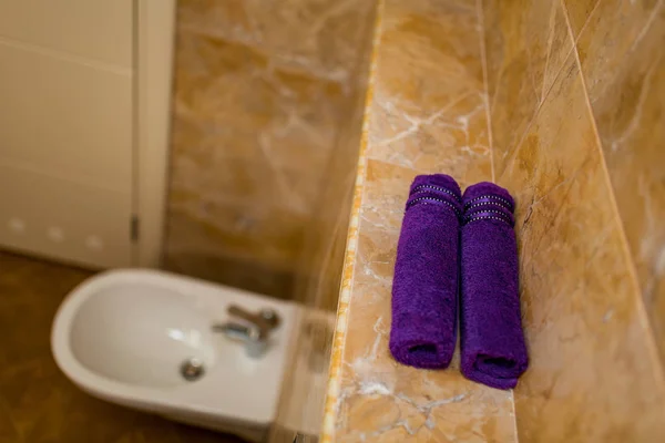 Toalhas roxas no banheiro em rolos — Fotografia de Stock
