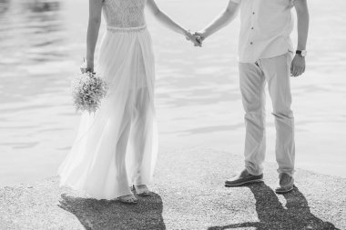 Yeni evliler, denizin üzerinde ellerini tutun. Elele çift. Ben düğün