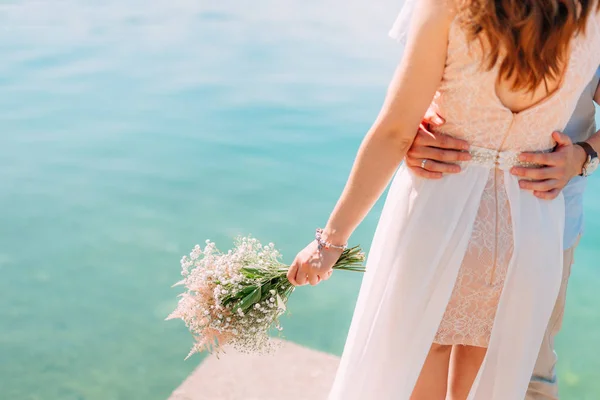 El novio abraza a la novia en la playa. Boda en Montenegro — Foto de Stock