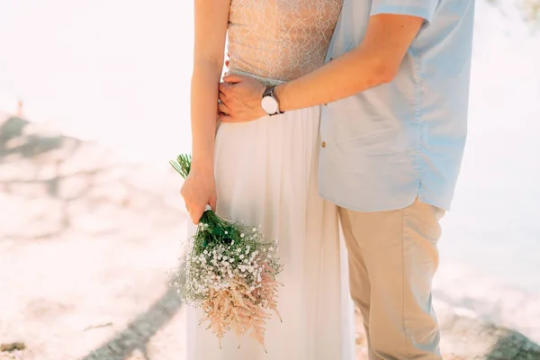 O noivo abraça a noiva na praia. Casamento em Montenegro — Fotografia de Stock